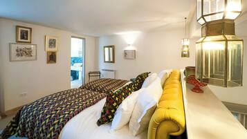A bedroom with a bed, a yellow headboard, and a bedside table with a lamp.