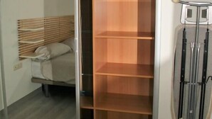 Ein Schlafzimmer mit einem Bett, einem Holzschrank und einem Fahrradständer.
