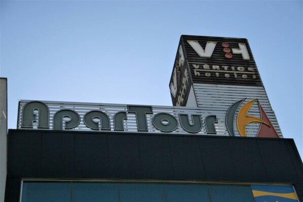 A building with a sign that reads "ApartTour" and "Vertice Hotels".
