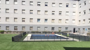 Un edificio moderno con piscina, circondato da un'area recintata.