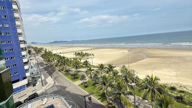A high-rise building with a rooftop pool area and a view of a beach. - Foot in the sand at Maracanã beach II (Praia Grande)