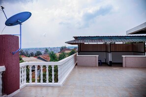 A balcony with a satellite dish, a white railing, and a view of the cityscape. - Prestige villa palace (Kigali)