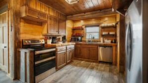 Una cucina rustica con mobili in legno, un frigorifero in acciaio inossidabile e una lavastoviglie.