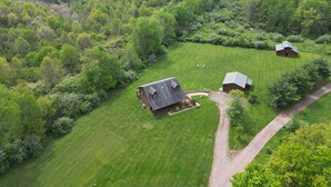 A rural property with a large house, a smaller barn, and a well-maintained lawn. - Pioneer Lodge | Hocking Hills, Sleeps 15, Hot Tub (Logan)