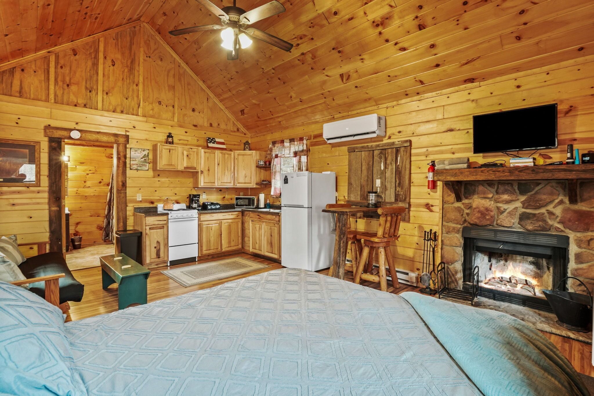 Interno di una baita in legno con cucina, zona pranzo e camino.