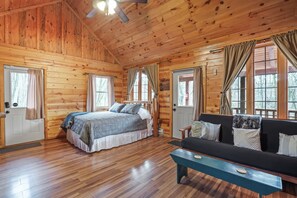 Eine Holzhütte mit einem Bett, einem Sofa und einer Bank.