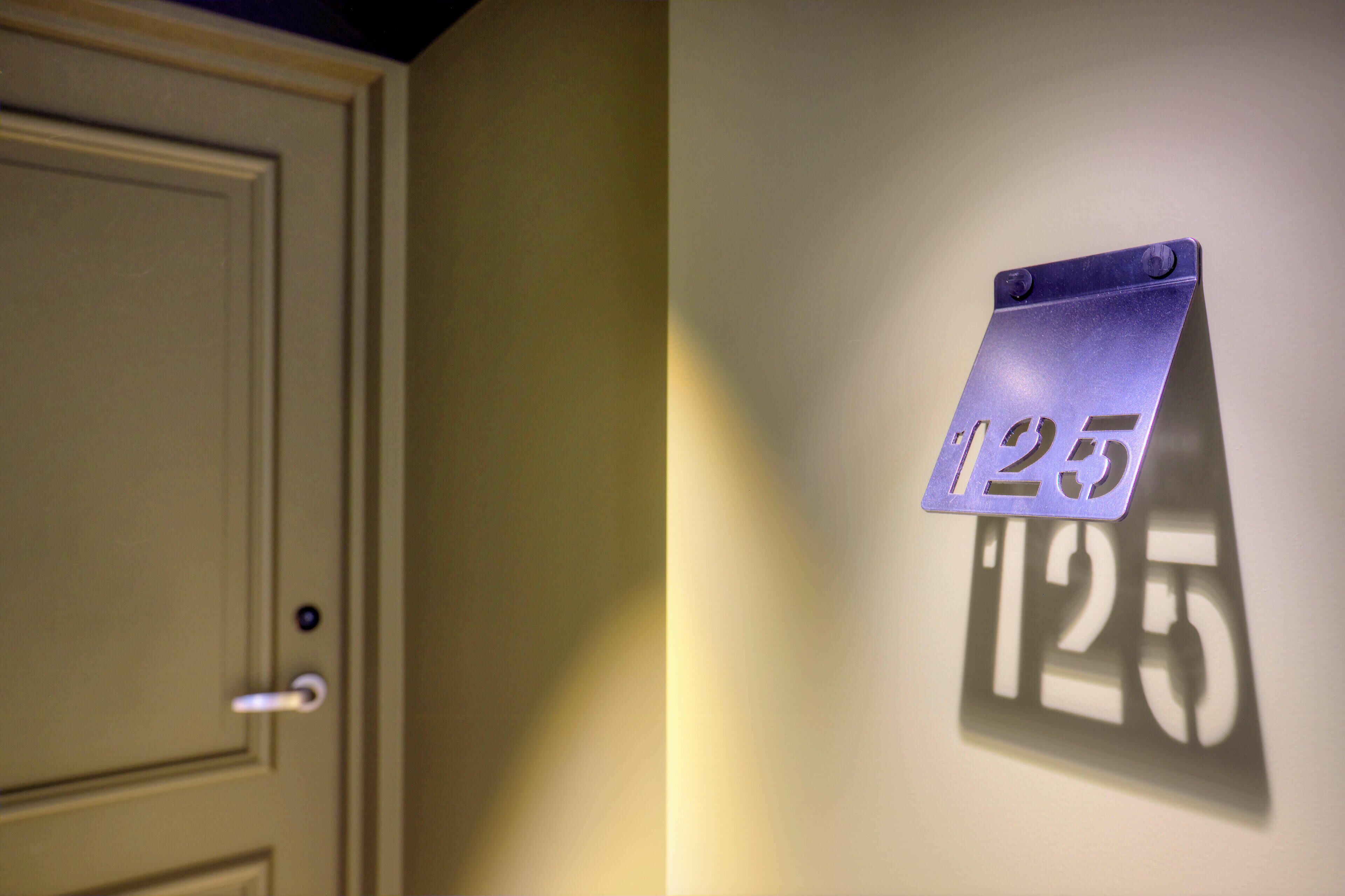 Une porte portant un panneau indiquant le numéro 125.