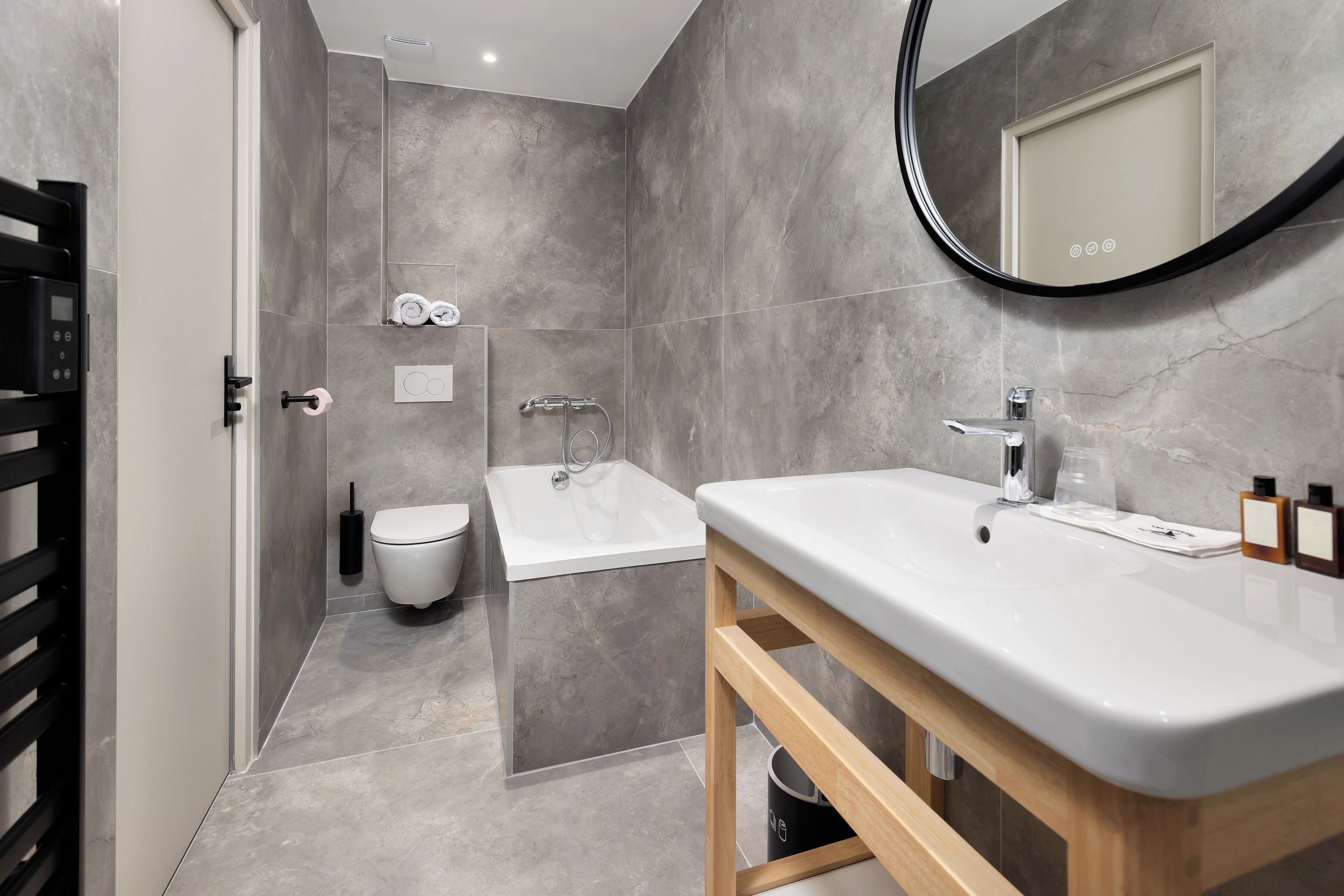 A modern bathroom with a bathtub, toilet, and sink.