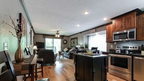 A spacious kitchen with wooden cabinets, stainless steel appliances, and a dining area with a table and chairs.