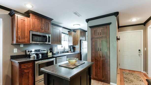 A kitchen with wooden cabinets, stainless steel appliances, and a central island.