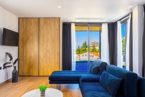 Deluxe suite, balkon, gedeeltelijk uitzicht op zee | Woonruimte | Televisie
