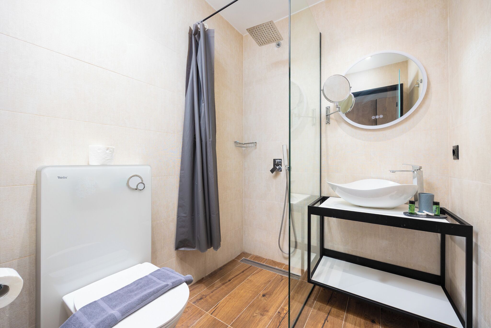 Et moderne badeværelse med toilet, bruser og håndvask.