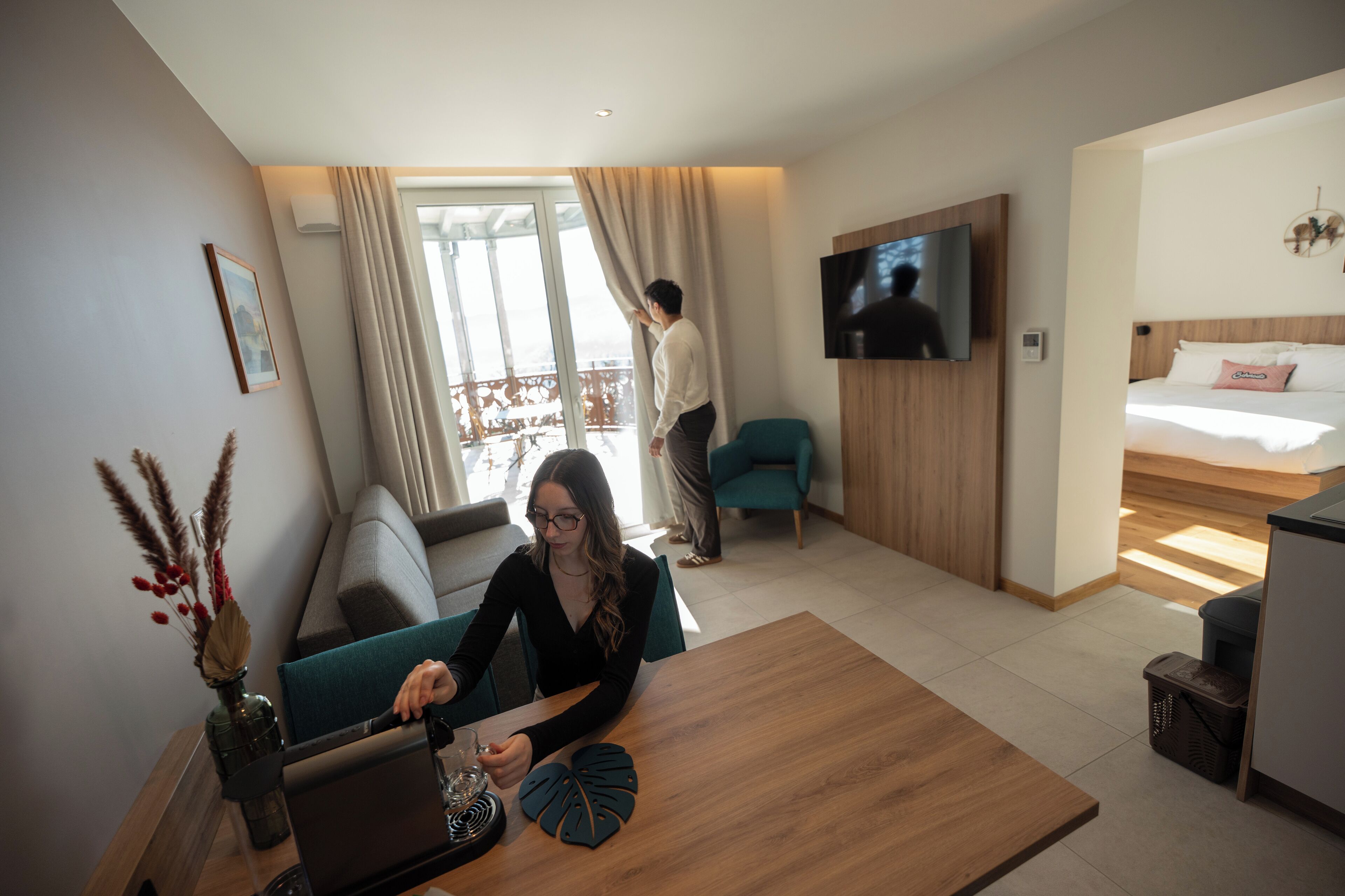Een hotelkamer met een bank, een salontafel, een televisie en een bed.