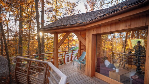 A wooden deck with a glass enclosure, a wooden staircase, and a seating area with chairs. - Domaine de Haslach, The Originals Collection, Résidence de Tourisme (Munster)