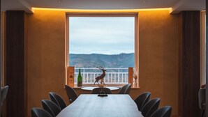 A conference room with a long table, chairs, a window with a view of hills, and a decorative deer statue. - Domaine de Haslach, The Originals Collection, Résidence de Tourisme (Munster)