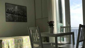 Un'area pranzo con tavolo e sedie, una pianta in vaso e un quadro appeso al muro.