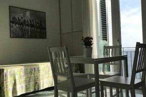 A dining area with a table and chairs, a potted plant, and a painting on the wall. - The Fig Tree "Villa Nunzia" (Barano D'ischia)