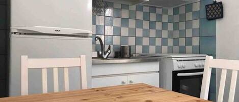 Uma cozinha com armários brancos, uma mesa de madeira e painel de azulejos.