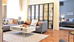 A modern living room with a sofa, coffee table, and a bookshelf. - Spacious 3-bedroom apartment in charming Budapest with AC, WiFi (Budapest)