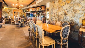 A restaurant with a stone wall, wooden ceiling, and a bar area. - Hotel Canto del Mar (La Serena)