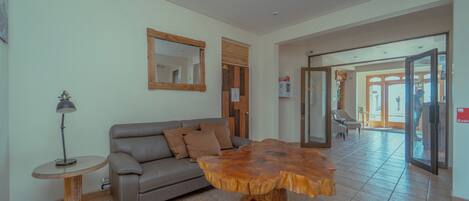 A modern living room with a wooden coffee table, a sofa, and a lamp.