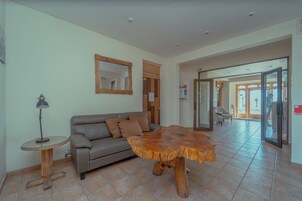 Una sala de estar moderna con una mesa de centro de madera, un sofá y una lámpara.