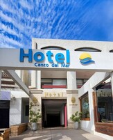 Un hotel llamado "Hotel Camino del Mar" con una entrada despejada, un logotipo con temática playera y un letrero visible que dice "Hotel" sobre la entrada.