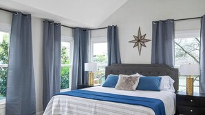Een slaapkamer met een bed, een plafondventilator, een sterrenversiering en uitzicht op de omgeving.