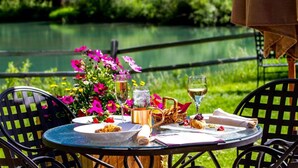 An outdoor dining table with plates of food, glasses of wine, and a basket of bread. - Keystone Lodge Room | Historic Charm & Breakfast (Keystone)