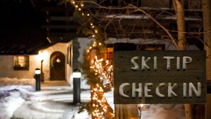 A sign reading "SKITIP CHECK IN" with a snowy pathway and lights in the background. - Keystone Lodge Room | Historic Charm & Breakfast (Keystone)
