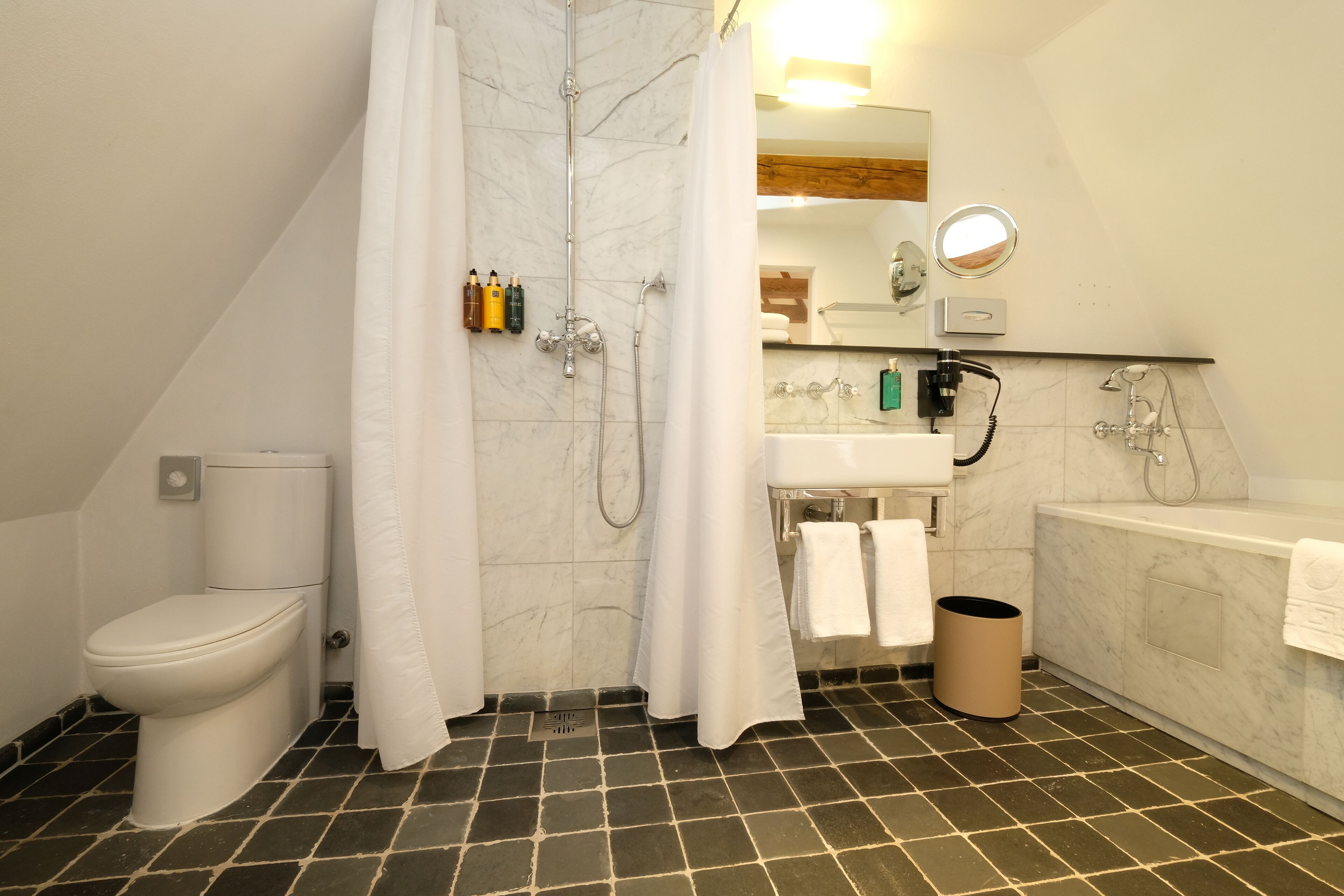 A bathroom with a toilet, shower, sink, and bathtub.