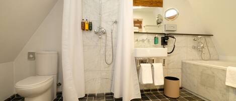 A bathroom with a toilet, shower, sink, and bathtub.