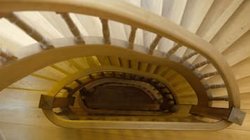 Una escalera en espiral de madera con barandilla central y peldaños de madera.