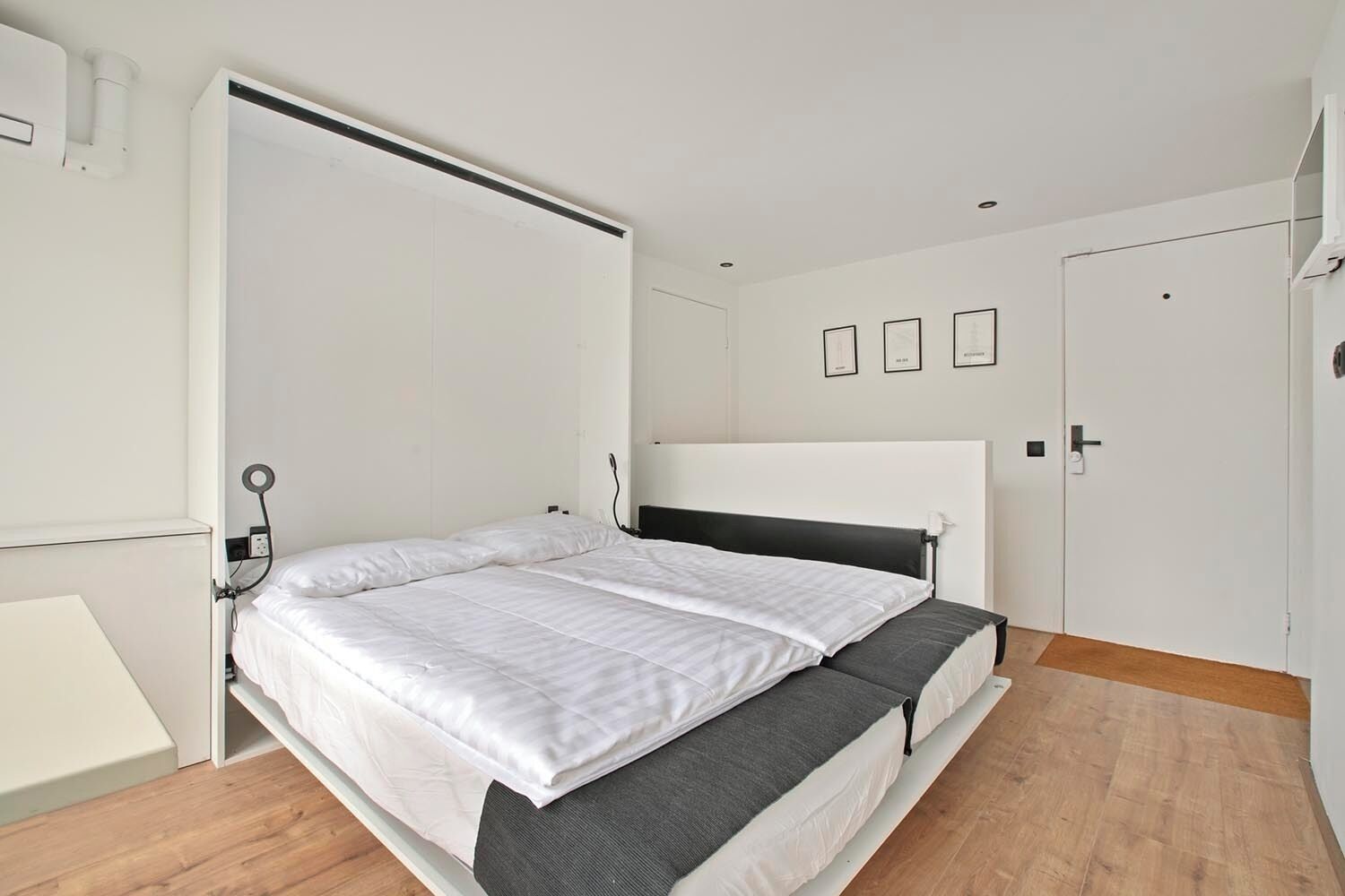Een slaapkamer met een bed, een kledingkast en een nachtkastje.