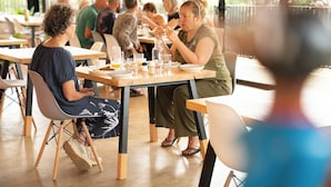 Un espace repas avec des tables et des chaises, une variété de plats et de boissons, et une vue sur l’extérieur.