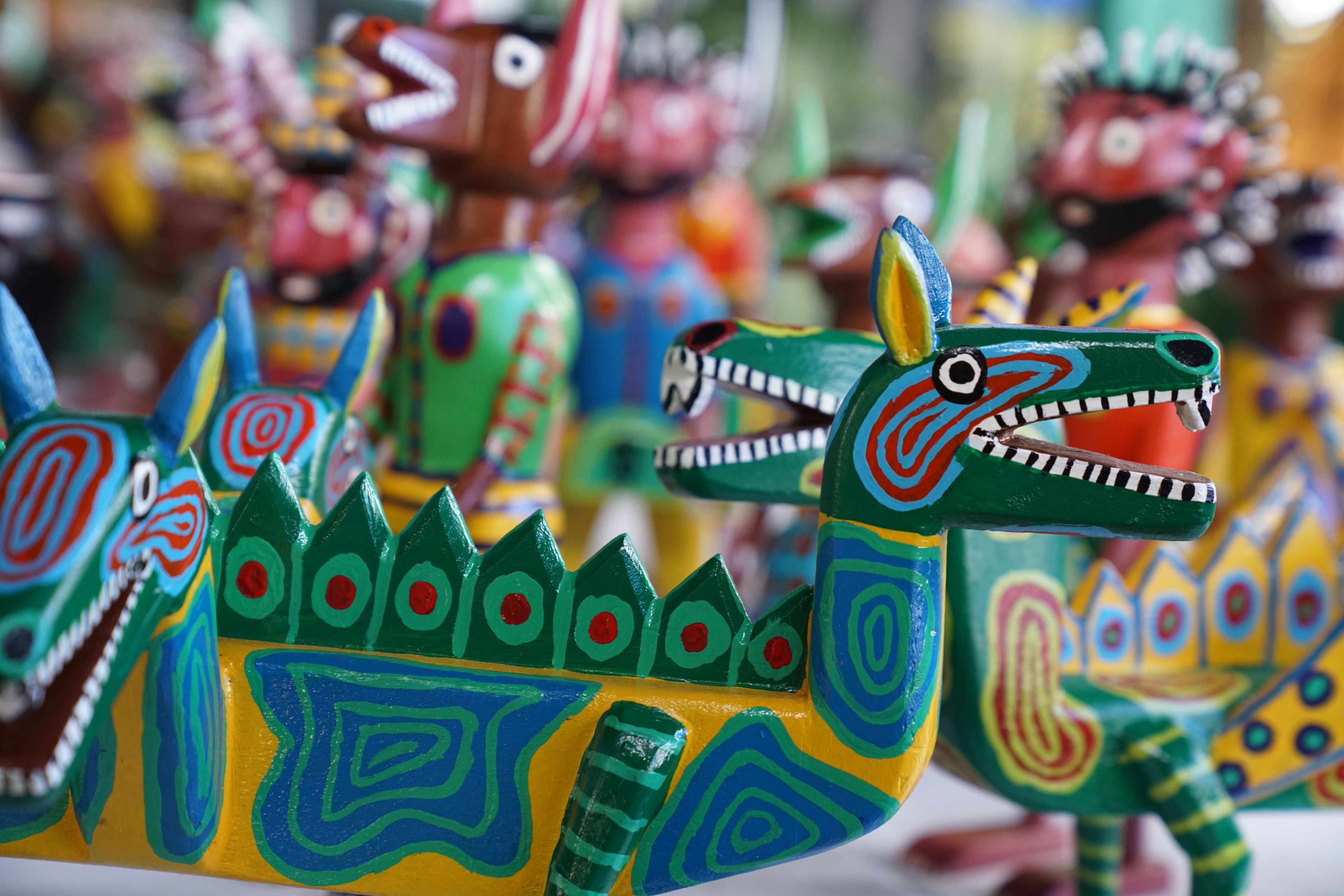 A collection of colorful, intricately painted wooden dragon figures.