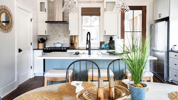 A modern kitchen with white cabinetry, a central island, and pendant lighting.