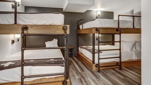 A room with bunk beds, wooden flooring, and wall-mounted lights. - Breckenridge Hotel Room | Group-Friendly Stay (Breckenridge)