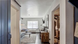 A hallway leading to a living area with a sofa, a round table, and a radiator. - Breckenridge Hotel Room | Group-Friendly Stay (Breckenridge)
