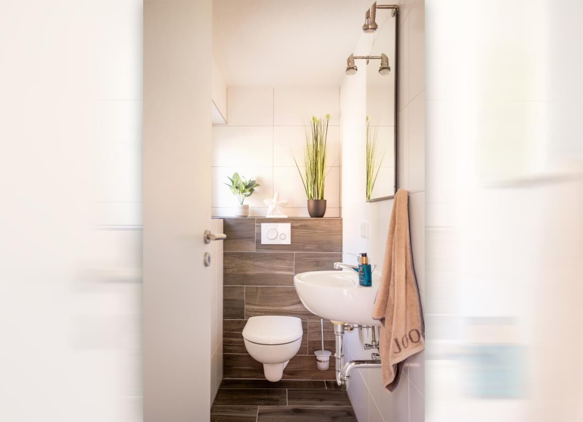 Un baño moderno con inodoro, lavamanos y espejo.