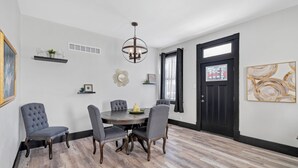 A dining area with a round table, four chairs, a chandelier, and a black door with a window. - The WashMO Hospitality House WALK to riverfront, shopping, wine shuttle, HOT TUB (Washington)