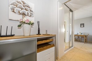 A modern kitchen with a wooden countertop, a white vase with flowers, and a decorative wall piece. - F rum Ocean View 5B by Homie (Funchal)