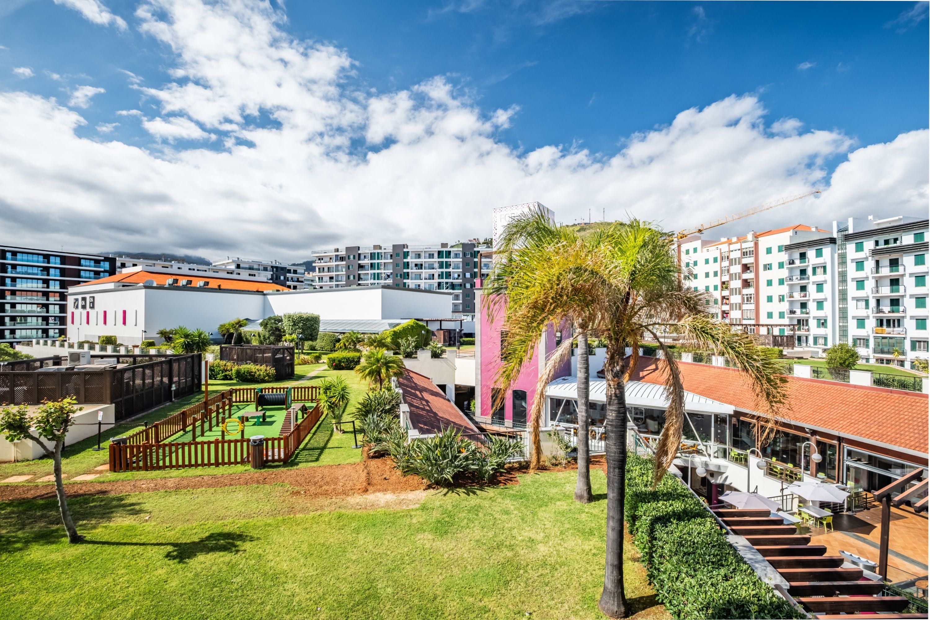 A residential area with modern buildings, a playground, and a well-maintained garden.