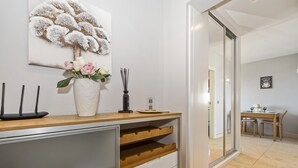 Una cocina moderna con encimera de madera, un jarrón blanco con flores y un adorno en la pared.