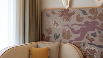 Une pièce moderne avec un canapé incurvé, une petite table ronde et un mur orné d’un motif.