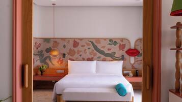 A bedroom with a bed, bedside table, lamp, and a wall with a floral pattern.