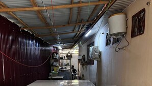 Une cuisine spacieuse dotée de plans de travail en marbre et d’un plafond haut.