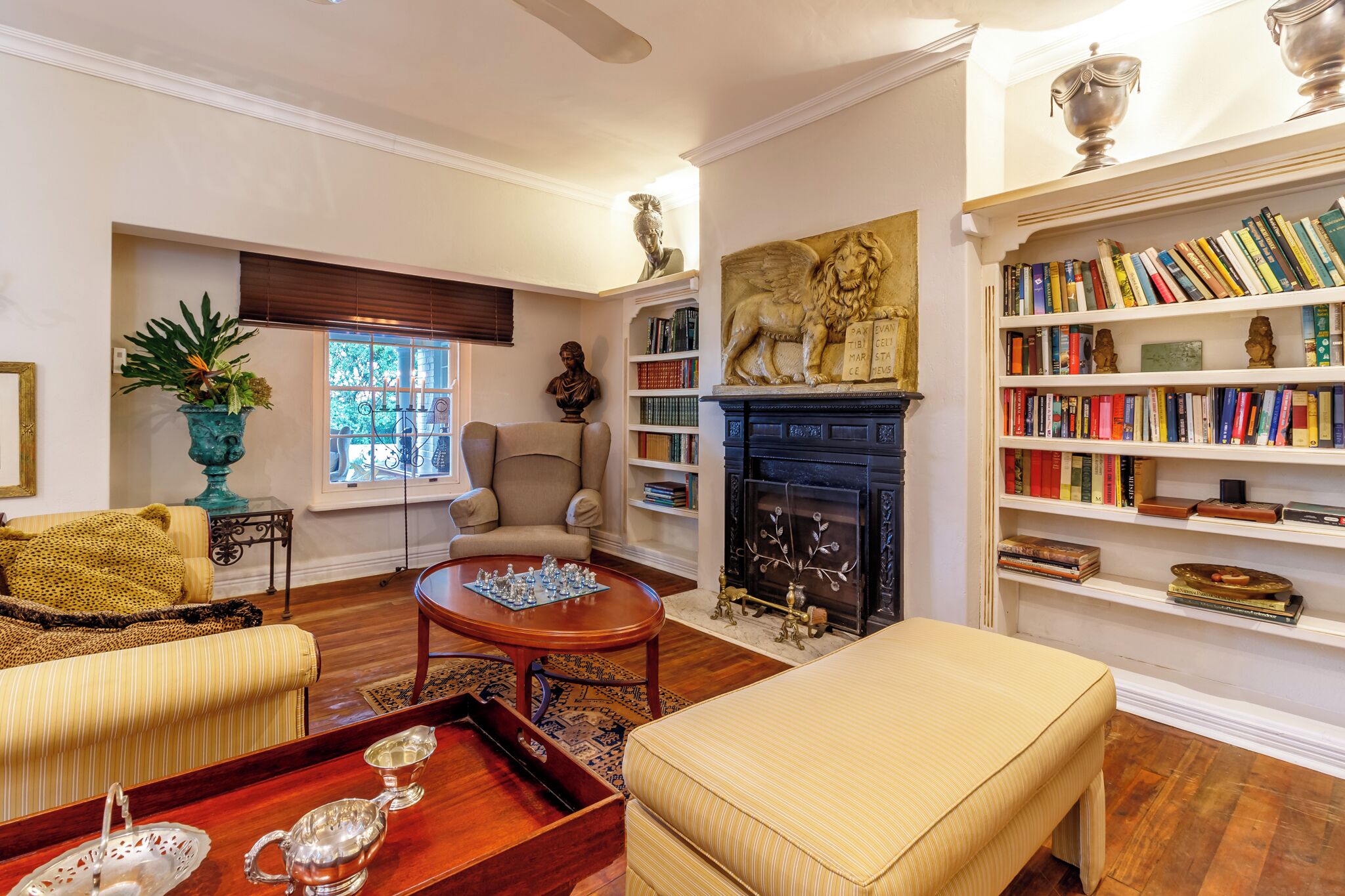 Una sala de estar bien amoblada con chimenea, estanterías, un sofá cómodo y una mesa de comedor con cubiertos.
