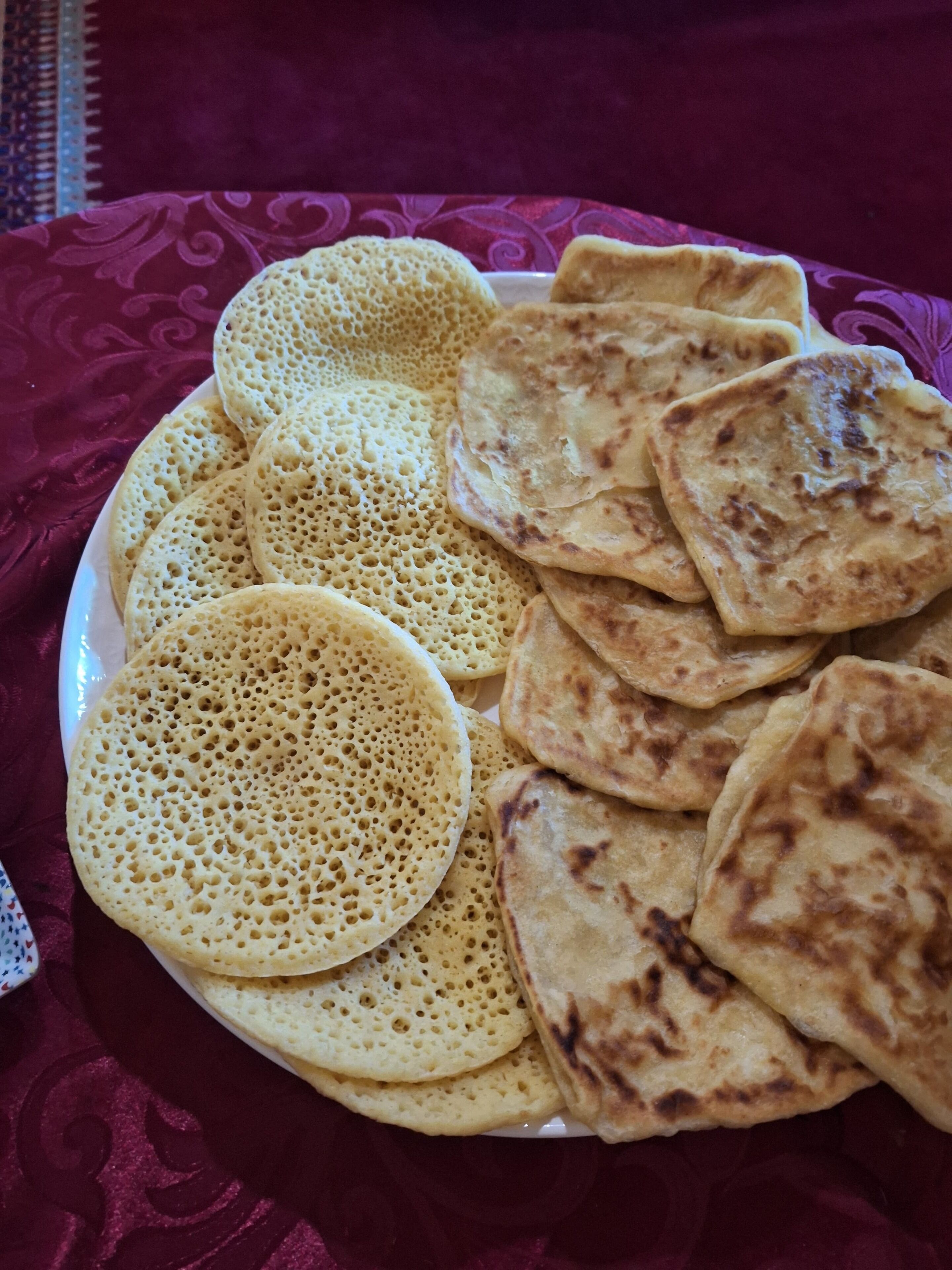 A plate of flatbreads and a patterned tablecloth.