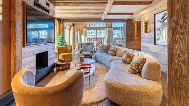 A cozy living room with a fireplace, comfortable seating, and a large TV.